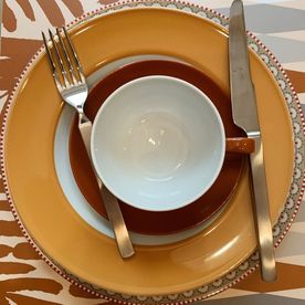Service mit Teller, Tasse, Untertasse und Besteck in Weiß, Gelb- und Orangetönen
