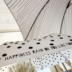 Weiße Regenschirme mit schwarzem Muster und Schriftzug